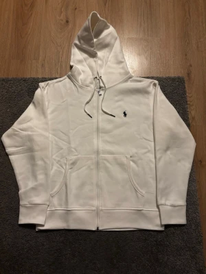 Polo Ralph Lauren Zip | Hoodie  - Snygg och tidlös zip hoodie från Polo Ralph Lauren i klassisk vit färg. 🤩 Mörkblå broderad logga på bröstet.  ✅Storlek S, och är i nyskick ✅Perfekt basic som funkar året runt