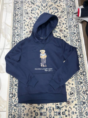Ralph lauren Bear hoodie - Marinblå Polo Bear hoodie. Använd 1 gång, nyskick. Papperslappen är avklippt. Väldigt clean och populär modell.