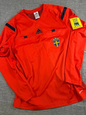 ⚽ Adidas SvFF Referee Jersey Neon Yellow Climacool L - Official Adidas SvFF Swedish Football Association referee jersey in high-visibility yellow with Climacool fabric. Features chest referee pockets, SvFF crest and Svenska Spel Fair Play sleeve patch. Lightweight breathable match official shirt. Great for referees, football collectors or sporty streetwear.  Size L  Measurements (flat): S2S 56 cm P2P 56 cm Length 70 cm