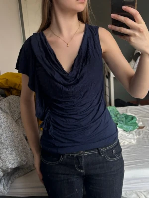Mörkblå draperad topp - Snygg mörkblå topp med draperad urringning och korta ärmar. 
