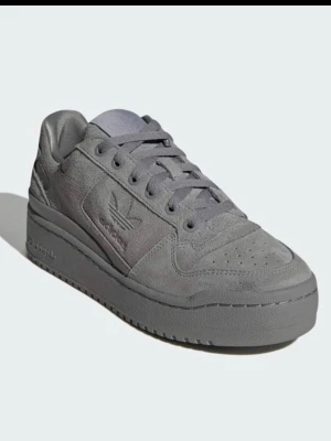 Adidas forum bold sneakers - Grå adidas platformsneakers, en nytolkning av Forum från 1984 med alla ursprungliga detaljer, mönster och material. Sköna. Använda men verkligen inte slitna. Upptäckte fort att det inte var ett storlek men hann försöka få det att gå. De är därför använda, men har sedan blivit stående. Går ej att få tag i längre, så passa på!
