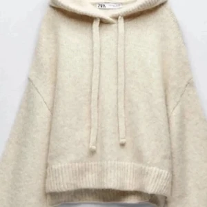 Beige hoodie från Zara med huva - Mysig beige hoodie från Zara med huva och dragsnören. Tröjan har en avslappnad passform, ribbade muddar och är tillverkad i ett mjukt stickat material som känns skönt mot huden. Perfekt för dig som gillar en enkel och stilren look. Den är i storlek M-L men passar mig som har xs-s