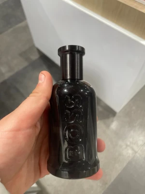 Hugo Boss Bottled Parfum - Snygg parfym från Hugo Boss i en svart, stilren flaska med BOSS-loggan i relief. Flaskan har en cylindrisk form och ger ett lyxigt intryck. Perfekt för dig som gillar eleganta och maskulina dofter. Kommer i originalförpackning.