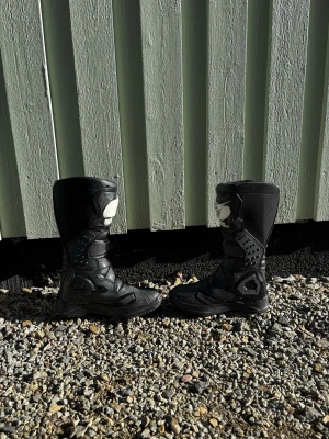 Svarta crossstövlar från O'Neal - Säljer ett par svarta crossstövlar från O'Neal med vita detaljer och kraftig sula. Stövlarna har spännen och förstärkningar för extra skydd, samt O'Neal-logga framtill. Perfekta för dig som gillar motocross eller enduro. Använda Ca 10 gånger. Storlek 41 passar även 42,5