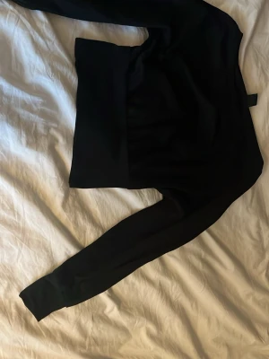 Svart tröja från Gina Tricot - En svart tröja från Gina Tricot i storlek S. Klassisk modell med långa ärmar och bred mudd vid midjan. Hoodien har en enkel och stilren look utan tryck eller detaljer, perfekt till jeans eller mjukisbyxor.