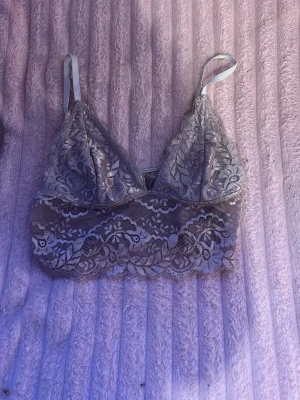 Rosa spetsbralette med tunna band - Säljer en snygg rosa bralette i spets med tunna axelband och vacker blommig spetsdetalj. Modellen är mjuk utan bygel och har en bred spetskant nedtill för extra komfort och stil. Perfekt för dig som gillar en feminin och bekväm look.