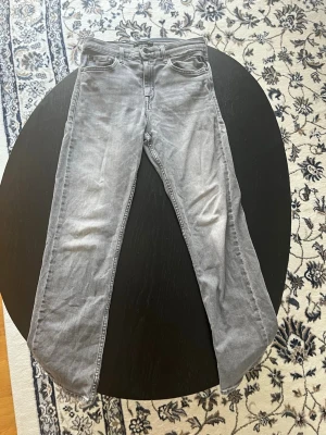 Grå jeans från Replay - Säljer ett par grå jeans från Replay i klassisk femficksmodell. Jeansen har raka ben och normal midja. Materialet är mjukt och stretchigt för extra komfort. Perfekta för dig som gillar en avslappnad men ändå stilren look.