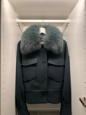 Meotine kappa - Säljer nu min fina pälskappa från meotine, den har en fin mörkgrön ton och en matchande päls till. Passar till alla lookar, och ger både en festlig men också vädligt elegant stil. Pälsen går dessutom att ta bort ifall man vill gå mer casual. Den är i mycket bra skick, skriv privat för fler bilder!