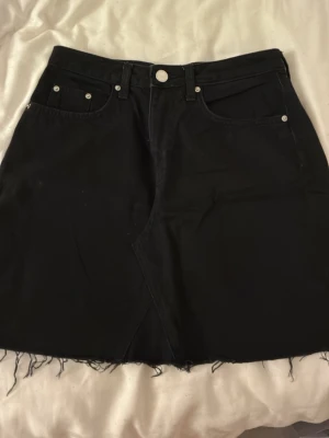 Svart jeanskjol från H&M Divided - Svart kort jeanskjol från H&M Divided.