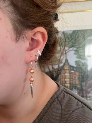 Orangea handgjorda pärlörhängen med nitar  -  Jag skapar dessa örhängen av noggrant utvalda pärlor från secondhand – ett medvetet val för att ge vackra material ett nytt liv. Alla örhängen är handgjorda och säljs i par 💖🫶🏻⚜️. Dessa örhängen har (metallen från de) en mörkare yta och är därför benämnda som acceptabelt skick🧡