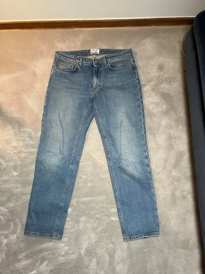 Blå raka jeans från Acne Studios  - Säljer ett par klassiska blå jeans från Acne studios i rak modell. Jeansen har fem fickor, normal midja och är gjorda i slitstark denim. Perfekta för dig som gillar en tidlös och enkel stil. Passar till det mesta och är riktigt bekväma.