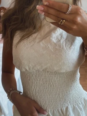 Vit blommig ärmlös topp - Supersöt vit topp med blommigt mönster och smockad midja. Så snygg topp💘 nytt skick!