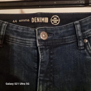 Mörkblå jeans från emma DENIM - Säljer ett par mörkblå jeans från emma DENIM med klassisk femficksmodell och snygg tvätt. Jeansen har normal midja, raka ben och metallknapp i midjan. Perfekta för dig som gillar en tidlös och enkel stil.