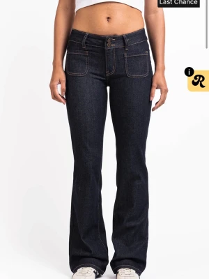 Mörkblå bootcut jeans från Madlady - Snygga mörkblå bootcut jeans från Madlady med dubbla knappar i midjan och kontrastsömmar. Jeansen har stora framfickor och bakfickor med lock och knappdetalj. Tillverkade i klassisk denim med en tidlös passform. Endast använda en gång. Nypris: 699kr