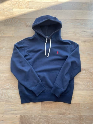 Mörkblå hoodie från Polo Ralph Lauren - Snygg mörkblå hoodie från Polo Ralph Lauren. Storlek S och passar dig runt 165-178cm. Hör av er vid frågor, priset är diskuterbart!