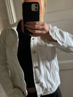 Vit jeansjacka med silverknappar - Snygg vit jeansjacka med klassisk rak passform och silverfärgade knappar framtill. Perfekt för dig som vill ha en fräsch och trendig jacka i garderoben. Skicka meddelande vid behov av fler bilder.