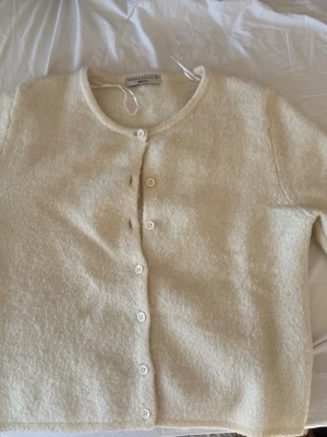 Krämvit kofta från Gina Tricot - Mysig krämvit kofta från Gina Tricot i fluffigt material. Koftan har rund halsringning, långa ärmar och knäpps med vita knappar framtill. Enkel och stilren design som passar perfekt till lager på lager. Inte finaste skicket , därav priset men har inga större märken mer än lige nopprig. Skicka dm om ifall ni ha fler frågor 💕