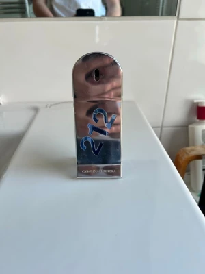 Carolina Herrera 212 Men parfym - Säljer en Carolina Herrera 212 Men parfym i en unik, futuristisk flaska med silverfärgad metall och blåa detaljer. Väldigt fräsch doft och säljer för att jag har tröttnat på den för jag har använt den så mycket. Ni ser på sista bilden hur mycket det är kvar ur 50 ml flaskan.