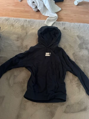 Svart hoodie från Levi's - Säljer en svart hoodie från Levi's med klassisk huva och magficka. Tröjan har en enkel design med en liten Levi's-logga på bröstet och ribbade muddar vid ärmar och nederkant. Perfekt för en avslappnad och stilren look.