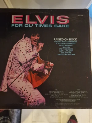 Elvis - Raised on Rock vinylskiva - Vinylskiva med Elvis Presley, albumet 'Raised on Rock / For Ol' Times Sake'. Omslaget är svart med en bild på Elvis i vit scenkostym och rosa text. Innehåller låtar som 'Find Out What's Happening' och 'Sweet Angeline'. Perfekt för samlare av klassisk rock och Elvis.
