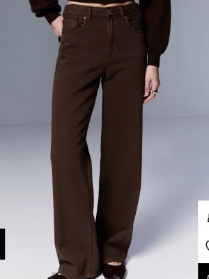 Bruna wide leg jeans från stradivarius  - Säljer ett par bruna wide leg jeans från Weekday med klassisk femficksdesign och hög midja. Jeansen har raka, vida ben och är tillverkade i ett kraftigt bomullsmaterial. Perfekt för dig som gillar en avslappnad och trendig look.