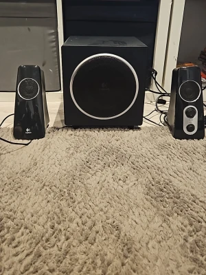 Logitech svart högtalarset - Säljer ett svart högtalarset från Logitech med två smala satellithögtalare och en kraftfull subwoofer. Högtalarna har en stilren design med rundade kanter och silverdetaljer. Perfekt för att boosta ljudet till datorn eller mobilen.