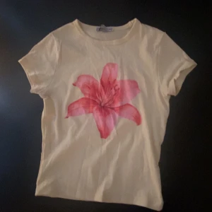 Gul t-shirt med rosa blomma - Från New Yorker, knappt använt!