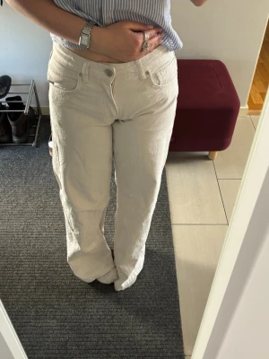 Vita lågmidjade wide jeans ifrån Zara - Jag säljer ett par riktigt snygga vita jeans ( pga felköp av storlek ) med rak passform och relativt låg midja. Jeansen har klassisk femficksdesign och stängs med knapp och dragkedja. Materialet ser ut att vara bomull med lite struktur, perfekta för en clean och avslappnad stil. Skriva gärna privat för frågor eller fler bilder!🫶🏻
