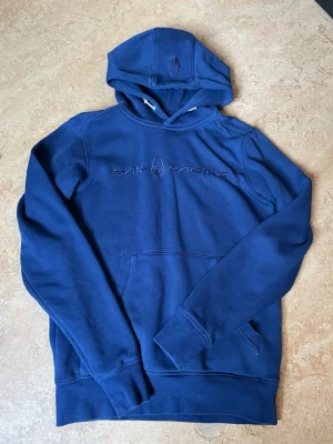  Sail Racing Hoodie i nyskick + Exklusiv Påse! 💎 - ✨ Detaljer: • Märke: Sail Racing • Storlek: XS (Passform: Slim fit / Sitter tajt och snyggt) • Färg: Marinblå • Skick: Mycket gott skick, väl omhändertagen. • Bonus: Original Sail Racing tygpåse medföljer vid köpet! 🛍️  • Höjd: 63 cm • Bredd: 43 cm  🚀 Snabb frakt: Jag skickar alltid inom 24 timmar!
