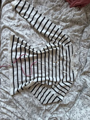 Vit och svart randig långärmad topp - Säljer en vit långärmad topp med svarta horisontella ränder. Tröjan har en klassisk rak passform och är tillverkad i ett mjukt material som känns skönt mot huden. Perfekt för dig som gillar en enkel men stilren look.  Aldrig använd!!!!!!!ACCESSOARERNA INGÅR EJ!!! OBS POSTAR ENDAST HELGER