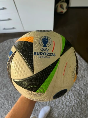 UEFA Euro 2024 fotboll - Säljer en officiell UEFA Euro 2024 fotboll i storlek 5. Bollen är vit med svarta, gröna, orangea och röda detaljer samt turneringens logga tryckt på. Perfekt för matcher eller träning med kompisarna.