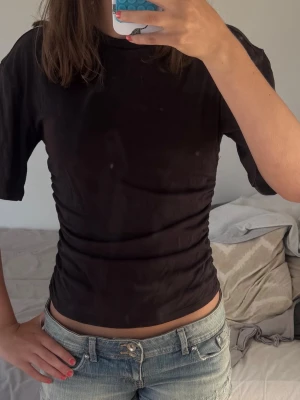 Brun blusliknande T-shirt - Säljer en brun t shirt från awake (köpt på Vero Moda) med indragen midja och lösare ärmar vilket gör den blusliknande. Jätteskönt stretchigt material. Storlek XS. 