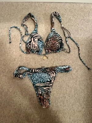 Bikini - Säljer en mönstrad bikini! Bikinin har ett unikt men utstickande mönster. Den har också justerbara band i överdelen, och en justerbar funktion i underdelen vilket gör den anpassbar💕