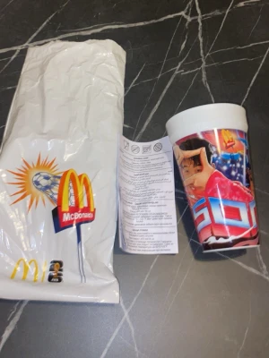 McDonald's FIFA plastmugg - Cool plastmugg från McDonald's med FIFA-tema och färgglad fotbollsgrafik. Muggen har motiv av en fotbollsspelare och McDonald's logga. Perfekt för samlare eller som rolig dryckesbägare.