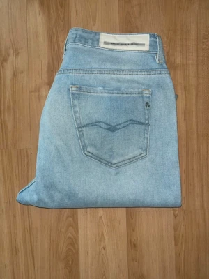 Replay jeans  - Säljer ett par ljusblå jeans från Replay. OBS vet ej om de är dam eller herr, det är köpta som herr men har glitter vid fickan (se bild) som gör mig osäker. Men det står slim boy fit - så skulle tro att det är herrjeans. Midja 38cm, längd 101cm. Ifall det inte finns någon bild i annonsen där jag bär plaggen jag säljer så är det för att jag ej kan ha storleken heller passformen, så kolla måtten för storlek och googla på modellnamnet för passform 😉 s5,2