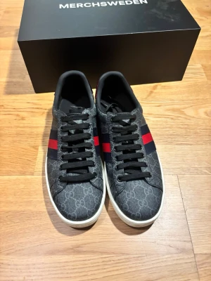 Gucci Ace GG - Säljer ett par klassiska och mycket eftertraktade Gucci Ace-sneakers i det ikoniska GG Supreme-mönstret. Dessa skor är ett statement-plagg som höjer vilken outfit som helst och kombinerar lyx med en modern streetwear-estetik. 