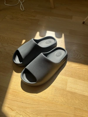 Yeezy slides  - Säljer mina svarta yeezy slides då dom inte passade mig, använda några få gånger och inte synliga tecken på användning. Skriv i dm vid frågor vill bli av med dom snabbt!