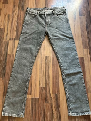 Jeans motén - Snygga grå jeans med rak passform och klassisk femficksdesign. Jeansen har normal midja och är tillverkade i ett mjukt denimtyg som ger en avslappnad look. Perfekta för dig som gillar en enkel och stilren stil. Dem är mindre i storlek än 36
