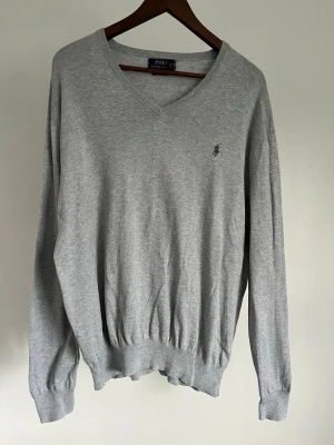Polo Ralph Lauren Pima Cotton V-neck - Polo Ralph Lauren Pima Cotton V-neck Storlek: XL Passform: Regular Fit Krage: V-neck Material: Bomull Mått: Bröstvidd 116 cm, längd 70 cm, axel 54 cm Skick: Tröjan är i ett väldigt fint skick utan defekter  Nypris cirka: 1 300 kr