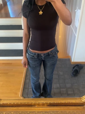 True religion bootcut jeans - Jenssen är mörkblå och jättebra skick.( Dom har inte nitar då jag tog bort dom) ser ganska nya ut och jag har sytt vid midjan och använt klädlim för att dom ska sitta bättre men det syns så klart inte när man ha på sig dom.  Lite slitna längst nere för att jag har trampat på dom. storlekw26/s