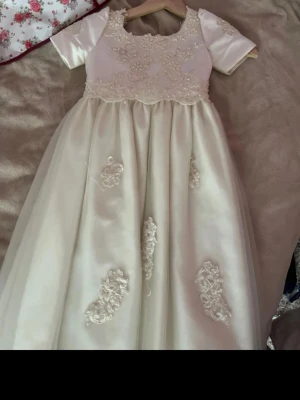 Vit prinsessklänning barn - 🤍 Superfin vit balklänning/prinsessklänning med vackra spetsdetaljer och pärlor. Klänningen har ett elegant fall och är perfekt till bal, bröllop, dop eller andra festliga tillfällen. Den är i fint skick och ger verkligen en sagolik look. ✨👑  ‼️OBS‼️ eventuella defekter visas tydligt på sista bilden, så kolla gärna där innan köp.💕  Säljs eftersom den inte längre kommer till användning. Hör gärna av dig om du har frågor eller vill se fler bilder! 💌