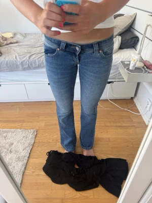 Blå lågmidjade jeans från Abrand Jeans - Säljer ett par blå bootcut superlågmidjade jeans från Abrand. Storlek 24 tall. Personen på bilden är 174. Köpta för 999kr.