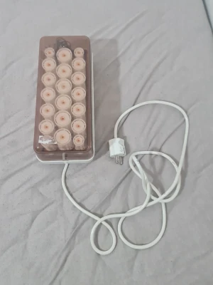 Carmen 20 värmespolar med låda - Säljer ett set med 20 värmespolar från Carmen i en vit och brun plastlåda. Perfekt för att fixa lockar snabbt och enkelt hemma. Spolarna är ljusbeige och kommer med tillhörande värmesystem och sladd för eluttag.