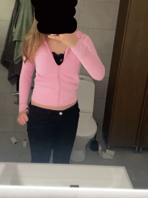 Rosa hoodie med dragkedja från Adidas - Säljer en ljusrosa hoodie från Adidas med dragkedja framtill och svart Adidas-logga på ärmen. Hoodien har luva. Är storlek 140 men passar mig oftast bär större.