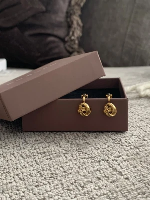 Guldpläterade clipsörhängen från Edblad Ny! - Örhängen i 14k guldplätering, nickelsäkra och i modellen ”Infinity Knot”. Tidlösa och eleganta 💎 perfekt till jobbet eller fest 🥂✨ Ask medföljer 🛍️💕I nyskick! 💕