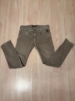 Replay jeans  - Snygga grå jeans från Replay, modell Anbass. Klassisk femficksdesign med smal passform och detaljerade sömmar. Perfekta för dig som gillar stilrena och bekväma jeans med modern look.