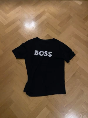 Svart BOSS t-shirt med tryck - Svart boss tröja i bomulls material, lite små defekter men inget synligt…men därför de låga priset.