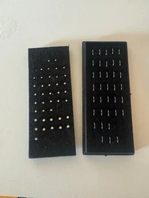  silverfärgade Näspiercing - Ett set med flera par små silverfärgade örhängen, både studs och hoops. Studsen har en rund form med glittrande detaljer, och hoopsen är enkla och klassiska. Alla örhängen är monterade på svarta hållare och passar perfekt för att mixa och matcha.