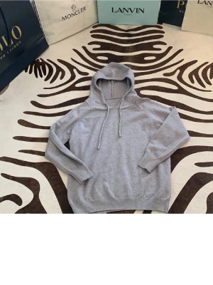 Merinoulls hoodie - Mysig grå hoodie med huva och dragsko. Tillverkad i mjukt material och har ribbade muddar vid ärmar och nederkant. Perfekt för en avslappnad och stilren look.