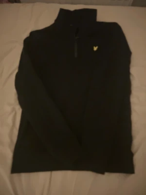 Svart tröja med halv dragkedja Lyle & Scott - Svart långärmad tröja från Lyle & Scott med halv dragkedja och ståkrage. En tröja som jag aldrig andvänder och den är helt ny 